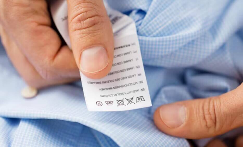 Etiqueta de roupa mostrando símbolos de secagem e lavagem