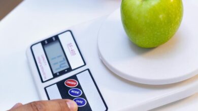 Pessoa usando a função tara da balança digital